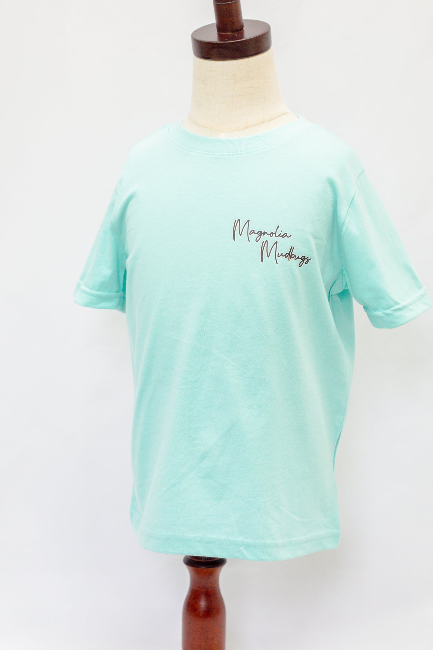 Mint green t-shirt on a mannequin with 'Magdalene Maudsley' text.