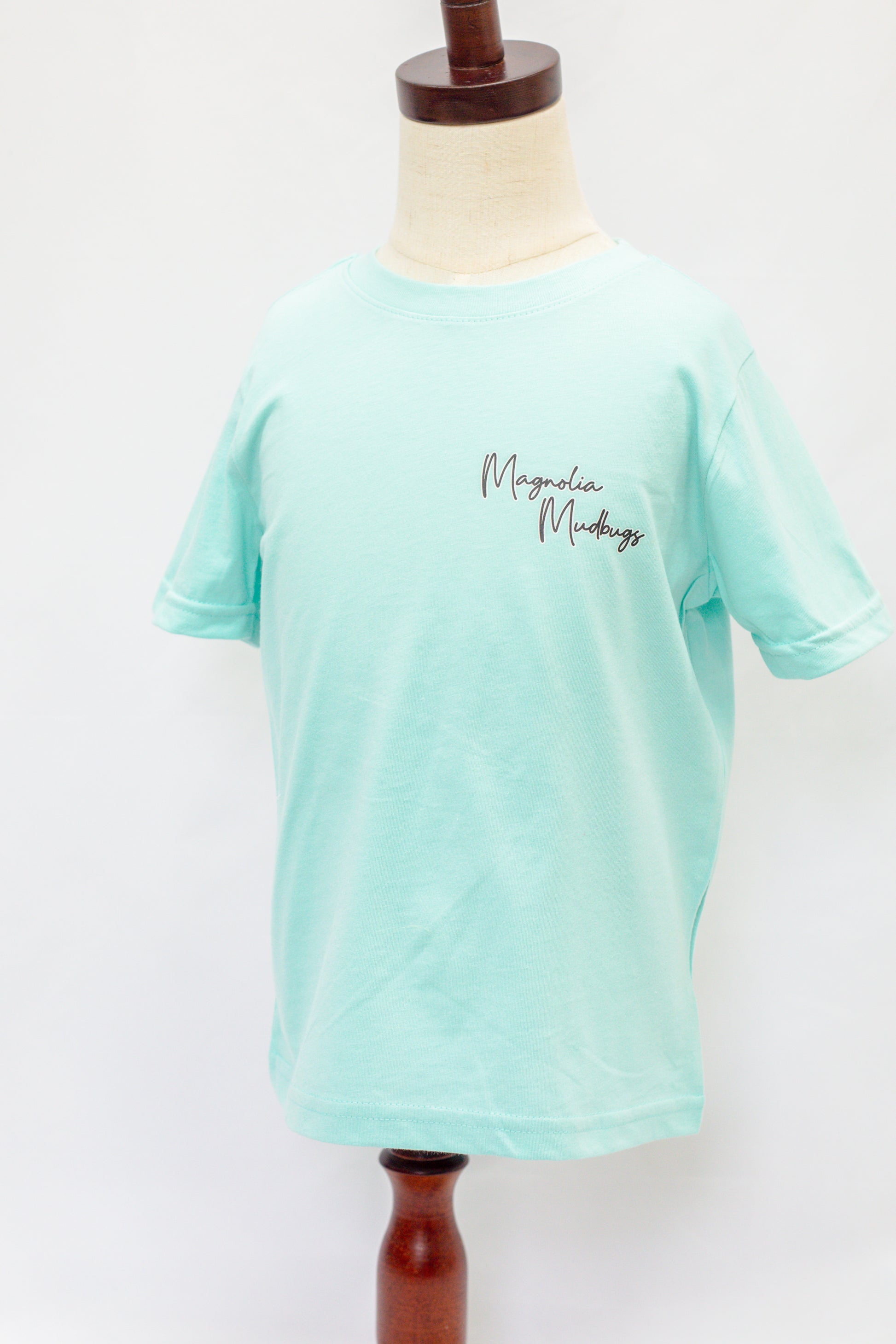 Mint green t-shirt on a mannequin with 'Magdalene Maudsley' text.